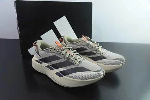 adidas Adizero Evo SL ATR na colorway Wonder Beige / Core Black / Solar Coral (tom bege/caqui leve com as três riscas escuras, pormenores em coral/laranja e atacadores de estilo trail/outdoor)