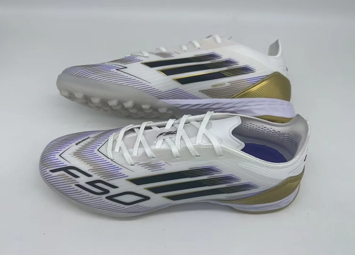 Adidas F50 Elite TF (em tom branco, dourado, roxo e detalhes em preto).