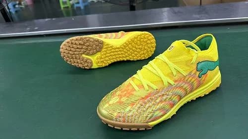 Puma Future Ultimate TT (em tom amarelo-fluorescente/lima com detalhes em laranja e verde, e sola para relva sintética/turf amarela e castanha/gum).